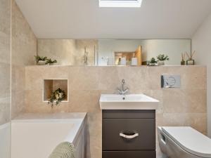 a bathroom with a sink and a tub and a toilet at 3 Bed in Loweswater 94152 in Arlecdon +10 photos