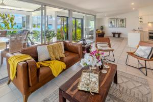 ハミルトン島にあるOasis Apartments on Hamilton Island by HIHAのソファとテーブルのあるリビングルーム