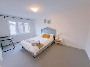 a white bedroom with a bed and a window at Vantage stay Modern 4BR townhouse pickering in Pickering