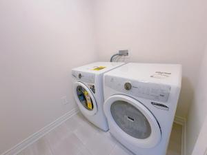 a washer and dryer in a white room at Vantage stay Modern 4BR townhouse pickering in Pickering
