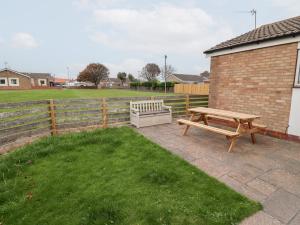 a picnic table and a bench in a yard at 51 Longstone Park in Chathill