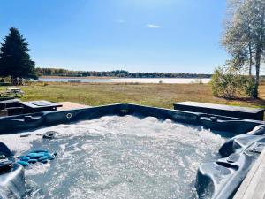 a hot tub filled with water in a field at Waterfront Cottage ''The Dream'' with Hot Tub, near Parlee Beach in Shediac
