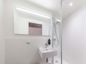 a white bathroom with a sink and a shower at ibis budget Perpignan Centre Rénové en 2025 - Hôtel Economique au Centre ville de Perpignan in Perpignan +138 photos