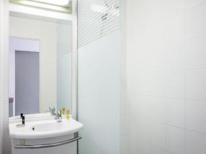 a white bathroom with a sink and a mirror at Greet Hotel Evreux Centre - Route de Normandie by Accor in Évreux