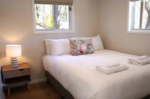a small bedroom with a bed with two towels on it at Sunshine Coast Hinterland Retreat - Yandina Station in Yandina Creek