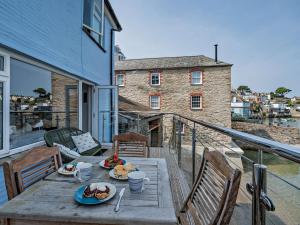 a wooden table with plates of food on a balcony at 2 Bed in Polruan PC074 in Fowey