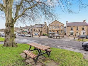 un banco de madera sentado en el césped junto a un árbol en 4 Bed in Middleton-in-teesdale 94274, en Middleton in Teesdale