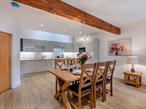 a dining room and kitchen with a wooden table and chairs at 3 Bed in Tollerton 93898 in Tollerton