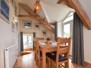 een eetkamer met een houten tafel en stoelen bij 3 Bed in Bude 86887 in Kilkhampton