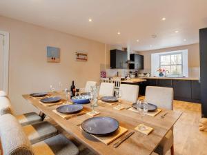 une table de salle à manger avec des chaises et une cuisine dans l'établissement 4 Bed in Pitlochry 89750, à Tummel Bridge