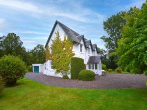 une grande maison blanche avec un toit noir dans l'établissement 4 Bed in Pitlochry 89750, à Tummel Bridge