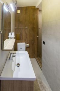 a bathroom with a white sink and a shower at City Apartments La Casa in Varna City +24 photos