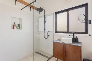 Un baño con ducha de cristal y lavabo. en 9 Callow Place, en Bermagui 25 fotos más