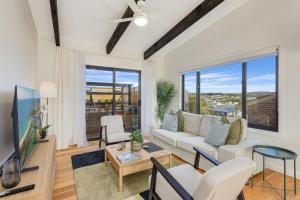 Una sala de estar con un sofá y un televisor. en 9 Callow Place, en Bermagui