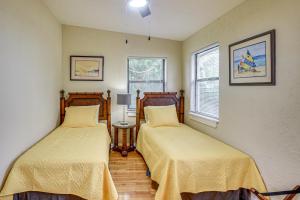 two beds in a room with two windows at 3 Mi to Beach and Boardwalk Riverfront Daytona Home in Holly Hill