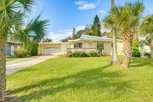 a house with palm trees in front of a yard at 3 Mi to Beach and Boardwalk Riverfront Daytona Home in Holly Hill