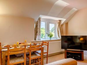 Great Longstoneにある1 Bed in Ashford-in-the-Water 87471のテーブルとテレビのあるダイニングルーム