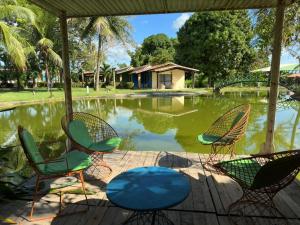 a group of chairs and a table in front of a pond at Complexo Barrigudos in Pacajus