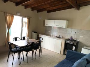 une cuisine avec une table et des chaises dans une pièce dans l'établissement Departamento Patagonia Alegre, à Puerto Madryn