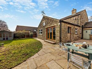 Redmireにある3 Bed in Leyburn 94415のパティオとテーブル付きのレンガ造りの家