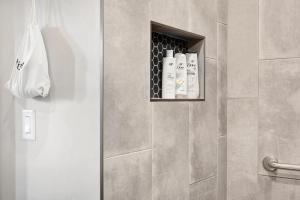 a bathroom with a shower with two bottles of soap at Blanco - A Birdy Vacation Rental in Fredericksburg +24 photos