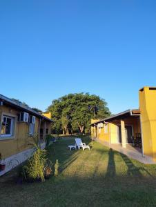 a yard with a bench in the middle of two houses at Cabañas Punta Iglesia in Paso de la Patria