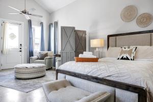 a bedroom with a large bed and a chair at Brazos - A Birdy Vacation Rental in Fredericksburg