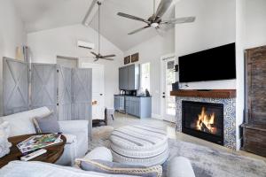 a living room with a fireplace and a tv at Brazos - A Birdy Vacation Rental in Fredericksburg