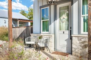 a house with two chairs and a door at Llano - A Birdy Vacation Rental in Fredericksburg