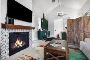 a living room with a fireplace and a tv at Llano - A Birdy Vacation Rental in Fredericksburg