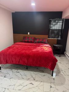 a bedroom with a red bed with a red blanket at Apartment near by NYC, EWR and Met Life in East Orange