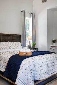 a bedroom with a bed with a blue and white comforter at Frio - A Birdy Vacation Rental in Fredericksburg