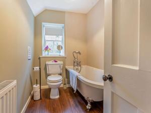 a bathroom with a toilet and a tub and a window at 4 Bed in Hawick 95765 in Roberton +22 photos