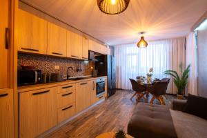 ティミショアラにあるMara Luxury Golden Art, Apartment PLUS Free Parkingのキッチン(木製キャビネット付)、ダイニングルーム