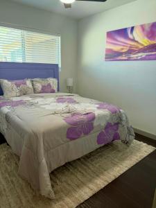 a bedroom with a large bed with a purple bedspread at Endless Summer, Pool, Theatre, Boat Parking, Walk to London Bridge! in Lake Havasu City
