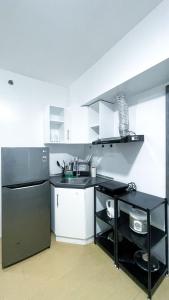 a kitchen with white cabinets and a black refrigerator at Warm Urban Studio with modern design in Molo