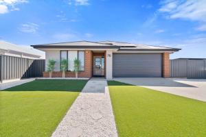 une maison avec un garage et une pelouse verte dans l'établissement The Ace Escape - Yarrawonga, à Yarrawonga