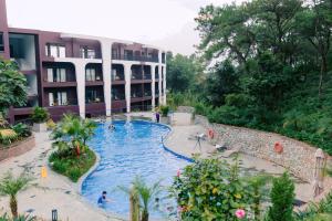 a resort with a swimming pool in front of a building at Soc Village Wellness & Retreat in Sóc Sơn