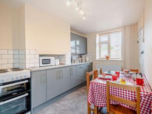 a kitchen with a table with a red and white table cloth at 2 Bed in Fakenham 92173 in Fakenham