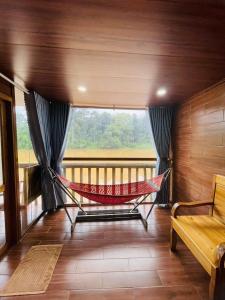 a hammock in a room with a large window at Cat Tien Nature Hotel in Cat Tien