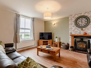 Sea Pallingにある4 Bed in Sea Palling 91480のリビングルーム(ソファ、テレビ、暖炉付)