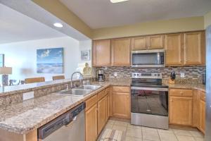 a kitchen with wooden cabinets and stainless steel appliances at Crescent Shores North - 1502 in Myrtle Beach