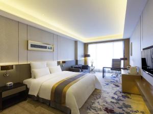 een hotelkamer met een groot bed en een televisie bij Pullman Changshu Leeman in Changshu