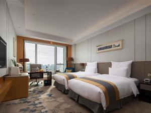 een hotelkamer met twee bedden en een bureau bij Pullman Changshu Leeman in Changshu
