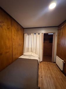 a small bedroom with a bed and a window at Hotel de la Costa in Talcahuano +2 photos