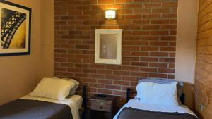 um quarto com duas camas e uma parede de tijolos em Hotel de la Costa em Talcahuano mais 1 fotografia
