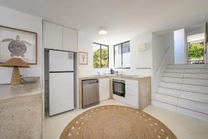 a kitchen with white appliances and a staircase at Ocean Vista Apartment, Sunrise Beach in Sunrise Beach