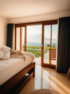 une chambre avec un lit et une grande fenêtre en verre dans l'établissement Pinggan Vista Alam, à Baturaja