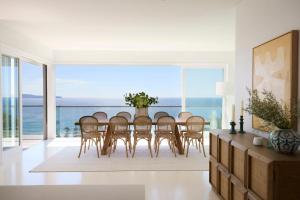 ein Esszimmer mit Tisch und Stühlen und dem Meer in der Unterkunft Salt in Palm Beach