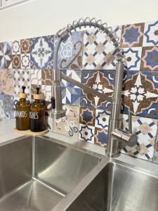 a kitchen sink with a faucet and two bottles of oils at Casa Blu - Vacation home in Chitre in Chitré